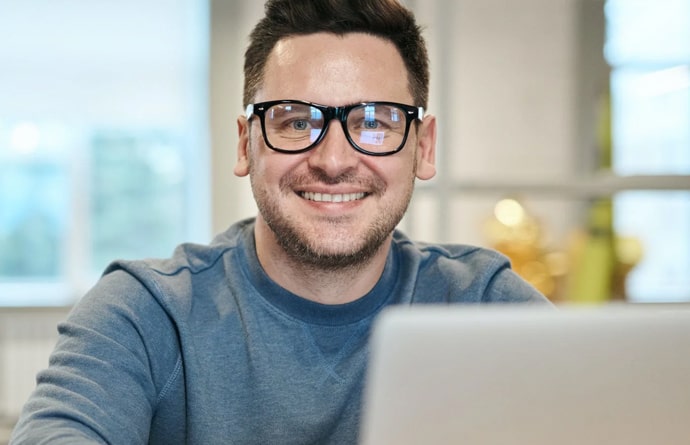 Image of men with glasses working on a laptop.